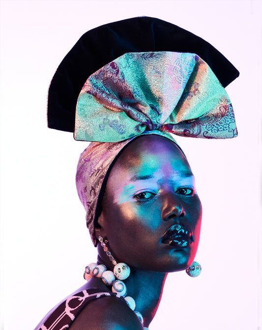 A vibrant and colorful artistic portrait of a woman with tribal makeup and a turban, featuring a mix of metallic and earthy tones.