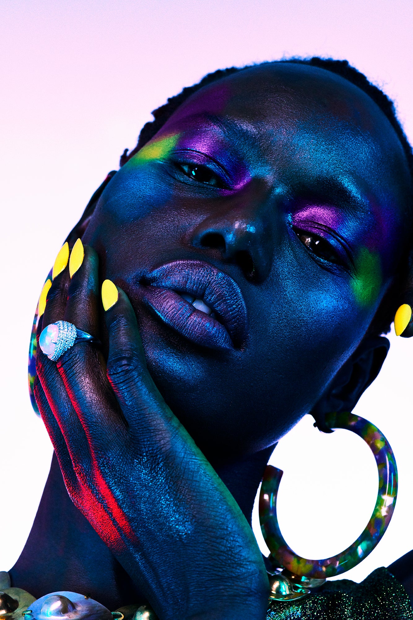 Close-up beauty editorial of a black woman wearing pops of colorful avant garde makeup and edgy jewelry. Shot for Vogue Portugal by Los Angeles beauty Photographer Jamie Nelson.
