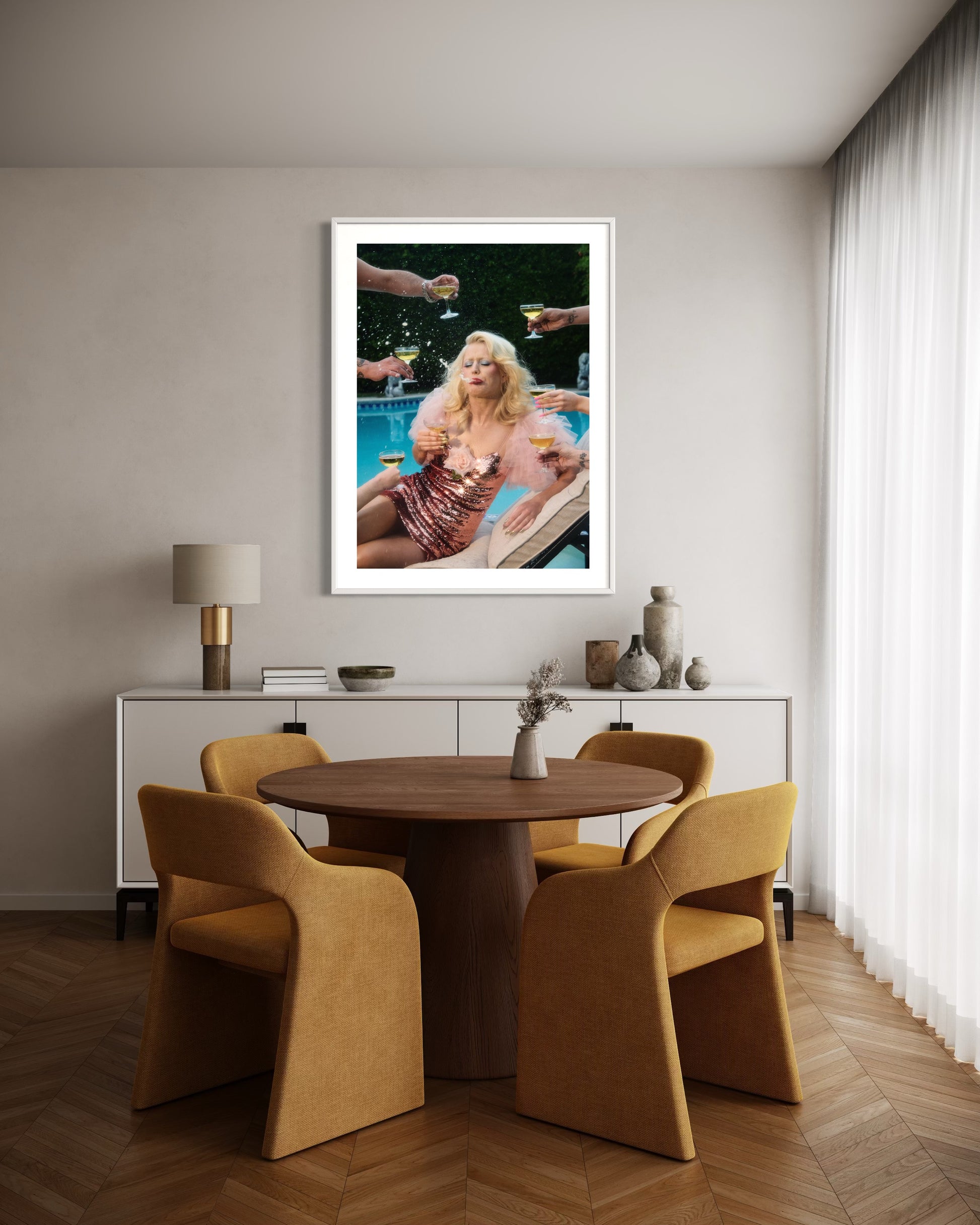 Dining room with a wooden table and chairs, framed artwork on the wall.