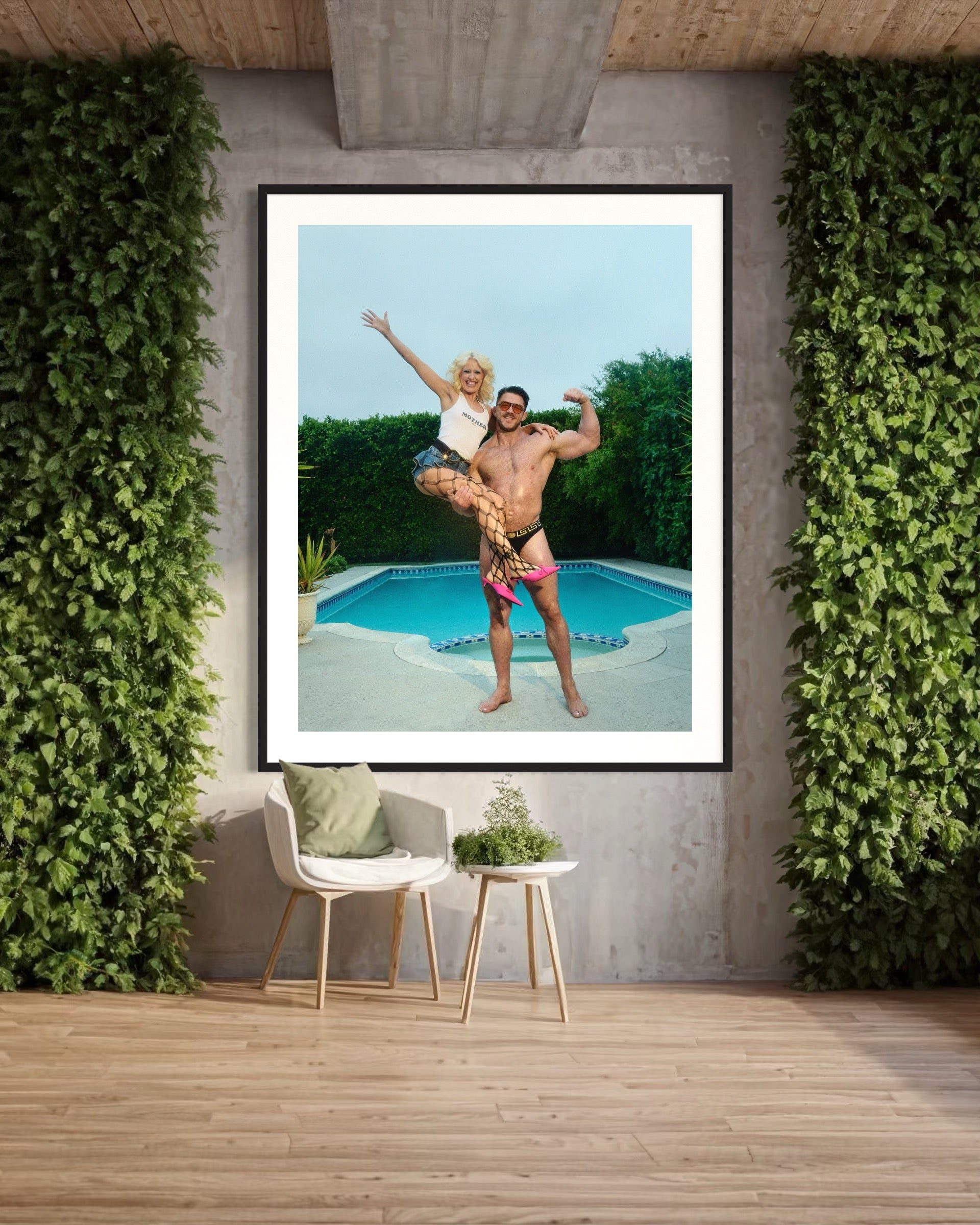 Framed photograph of a couple by a pool with greenery around.