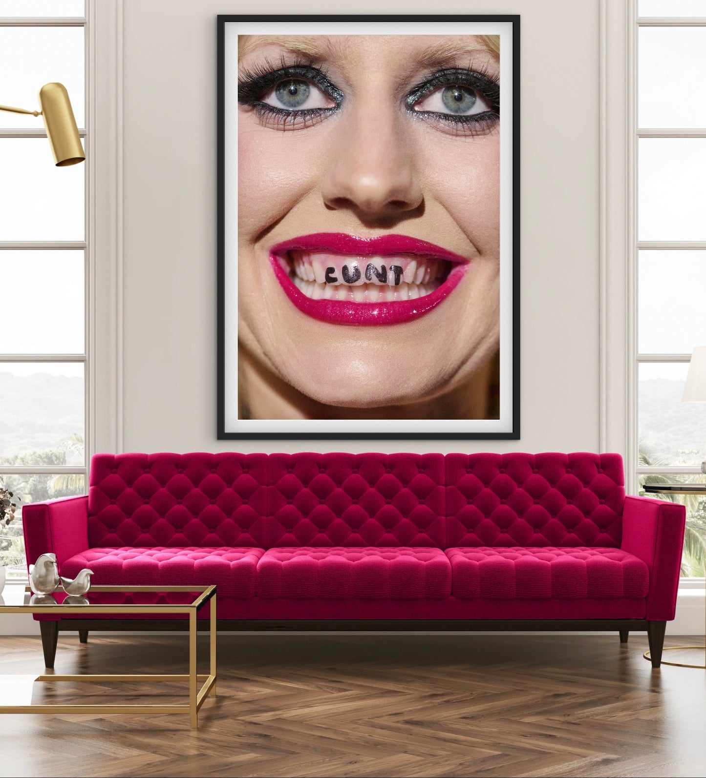 Framed artwork of a woman's face with visible teeth on a wall above a red sofa.