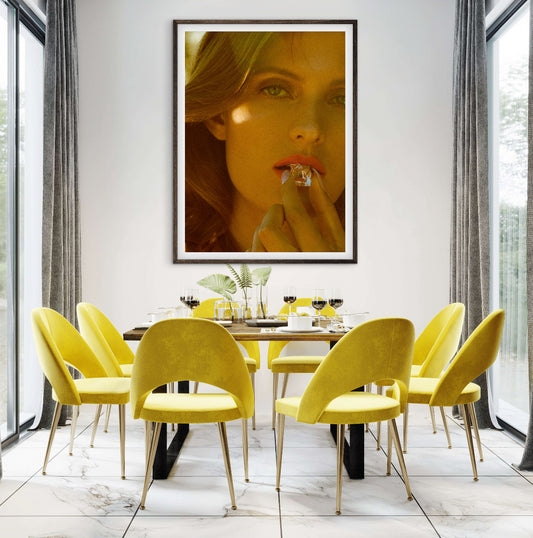 Dining room with yellow chairs and a large framed portrait on the wall.