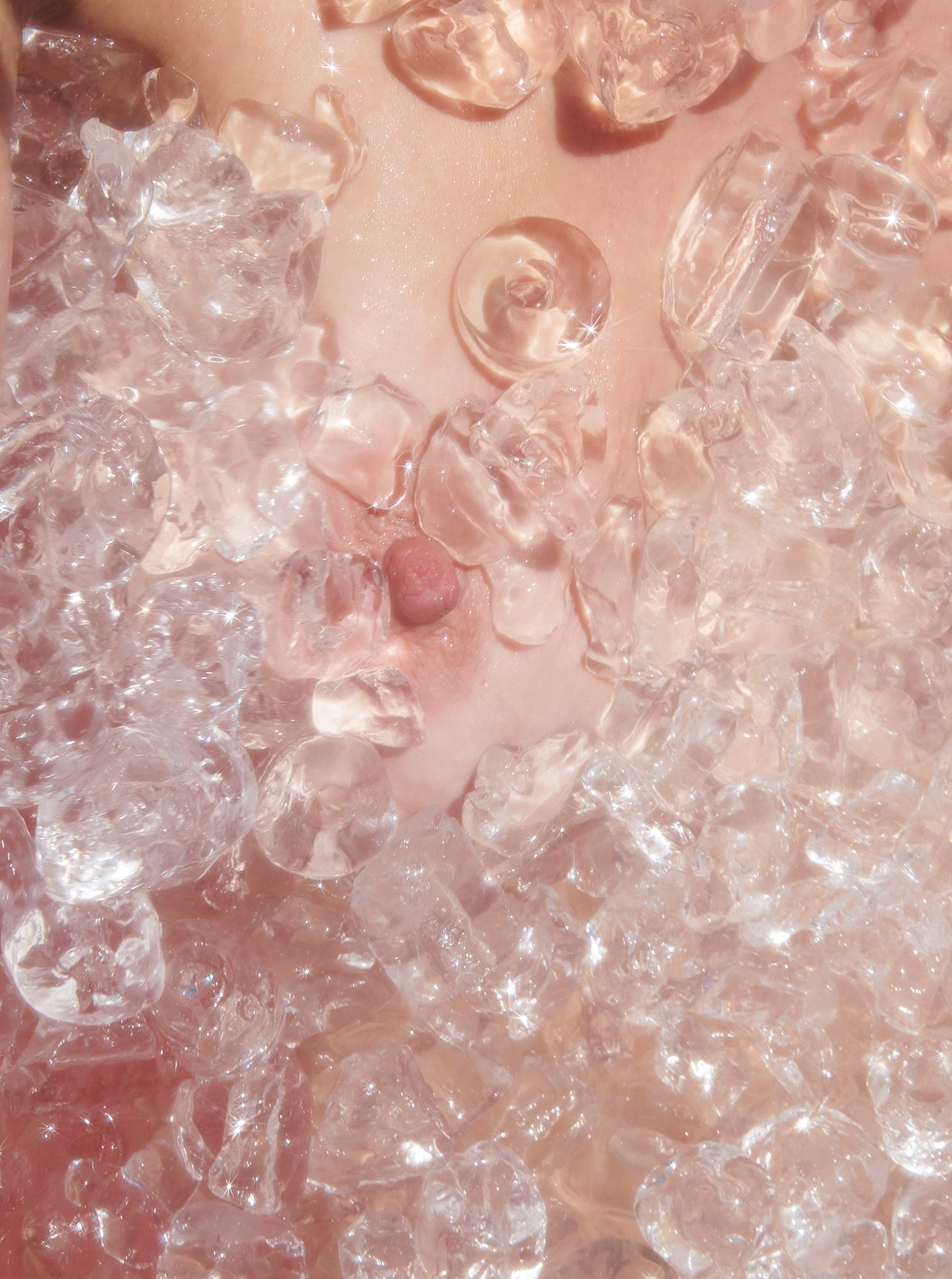 Woman's breast nipple surrounded by ice in ice bath cold plunge cryotherapy