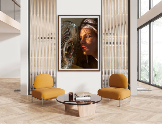 Modern interior with yellow armchairs, a round coffee table, and a large framed portrait on the wall.