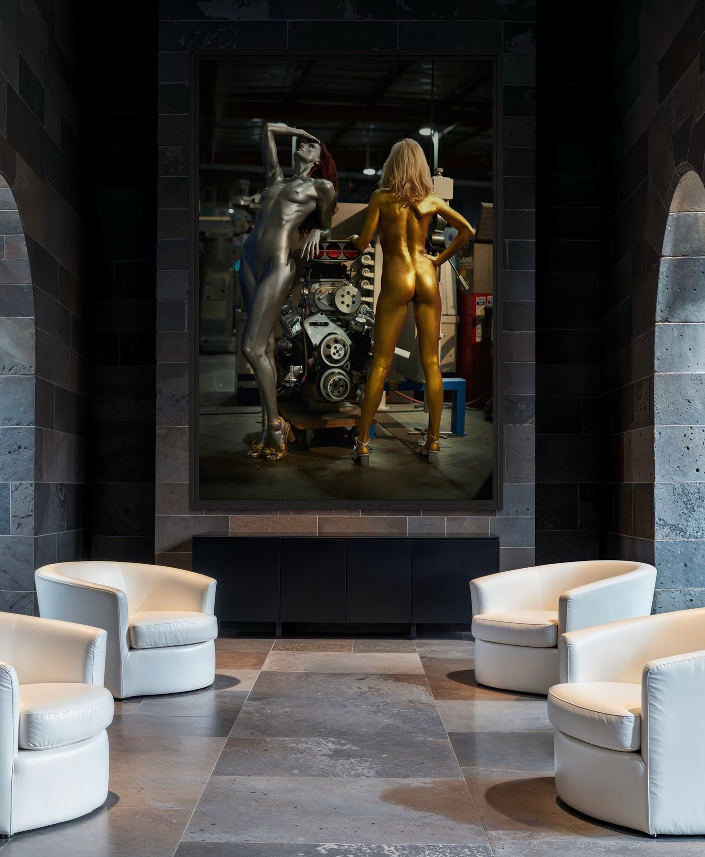 Modern interior with white chairs and a large wall art piece featuring two nude women in chrome and gilded body paint.