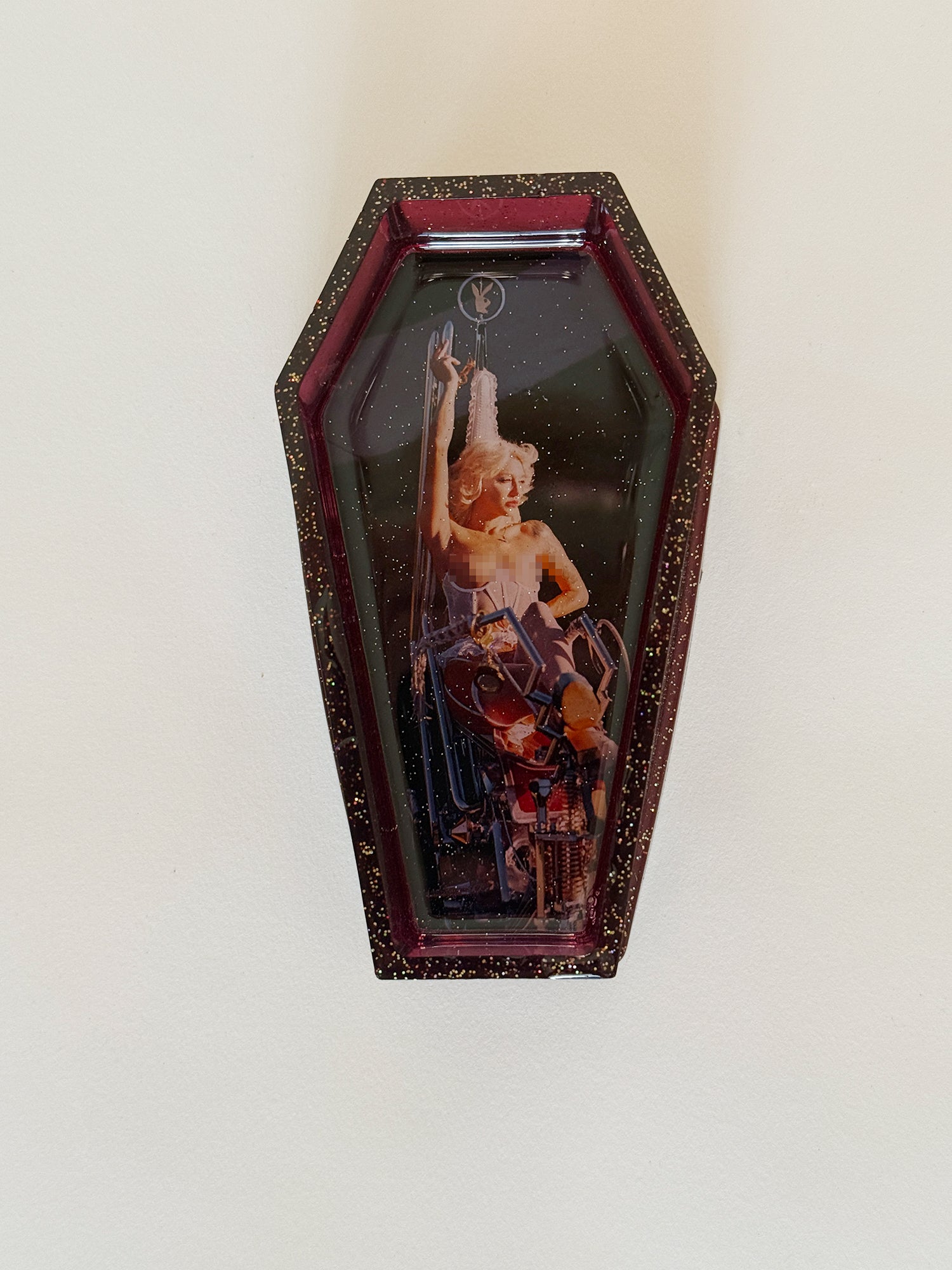 Decorative coffin-shaped box with a design on a white background