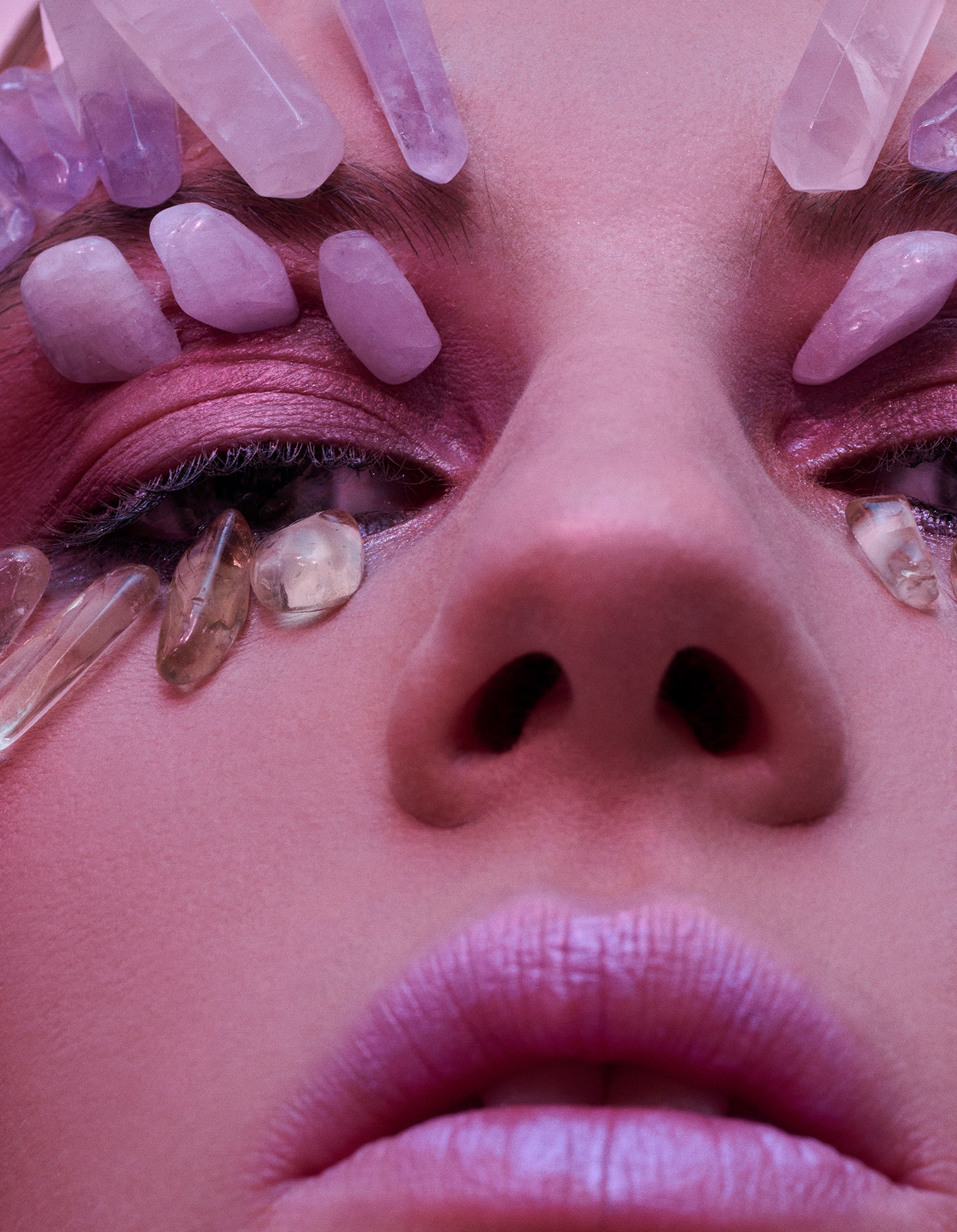Woman with lilac rose quartz amethyst stones on her eyes crystal healing therapy natural organic DIY beauty treatments