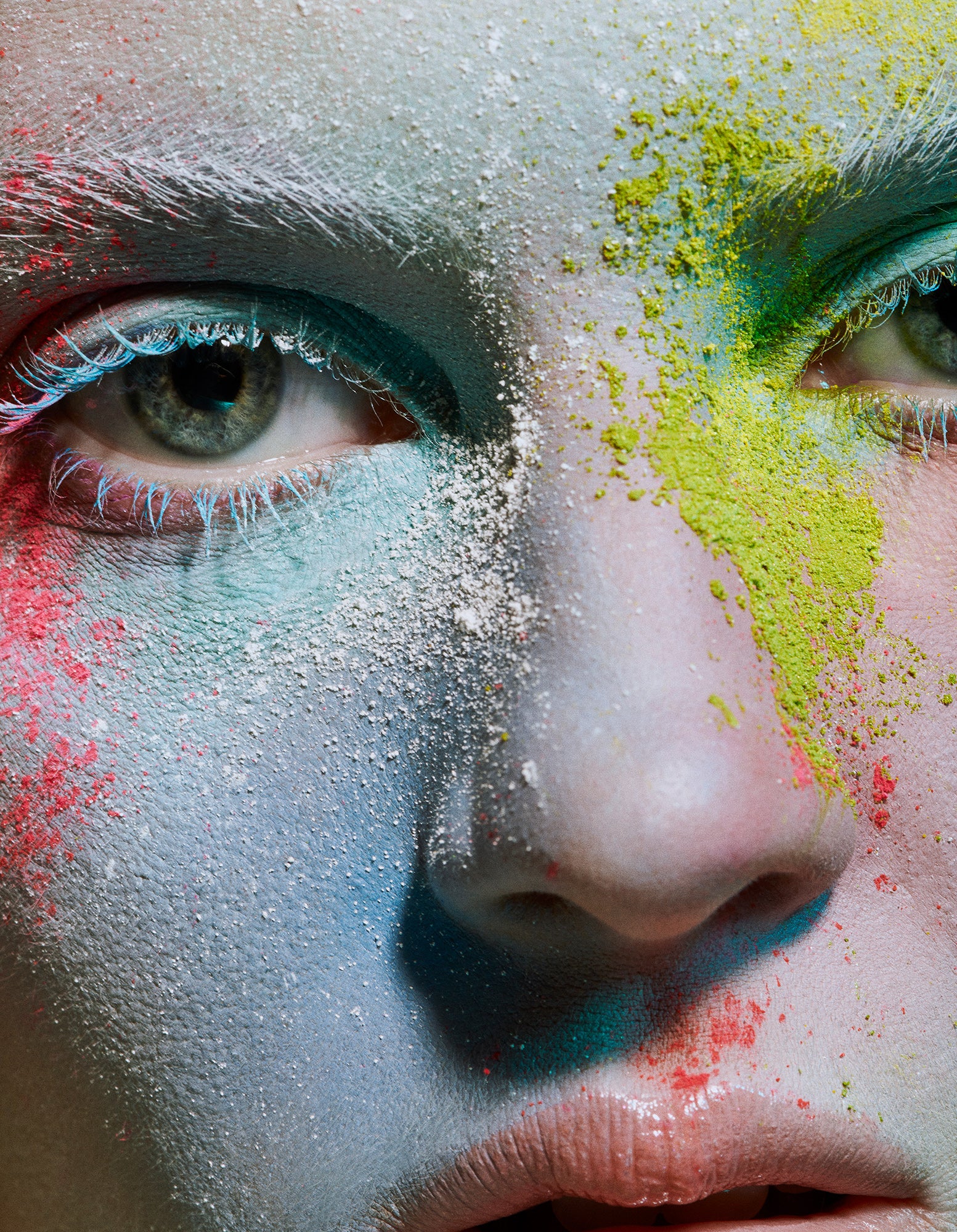 Close-up macro of woman female model wearing blue mascara covered in powder splash makeup that is of organic natural elements.