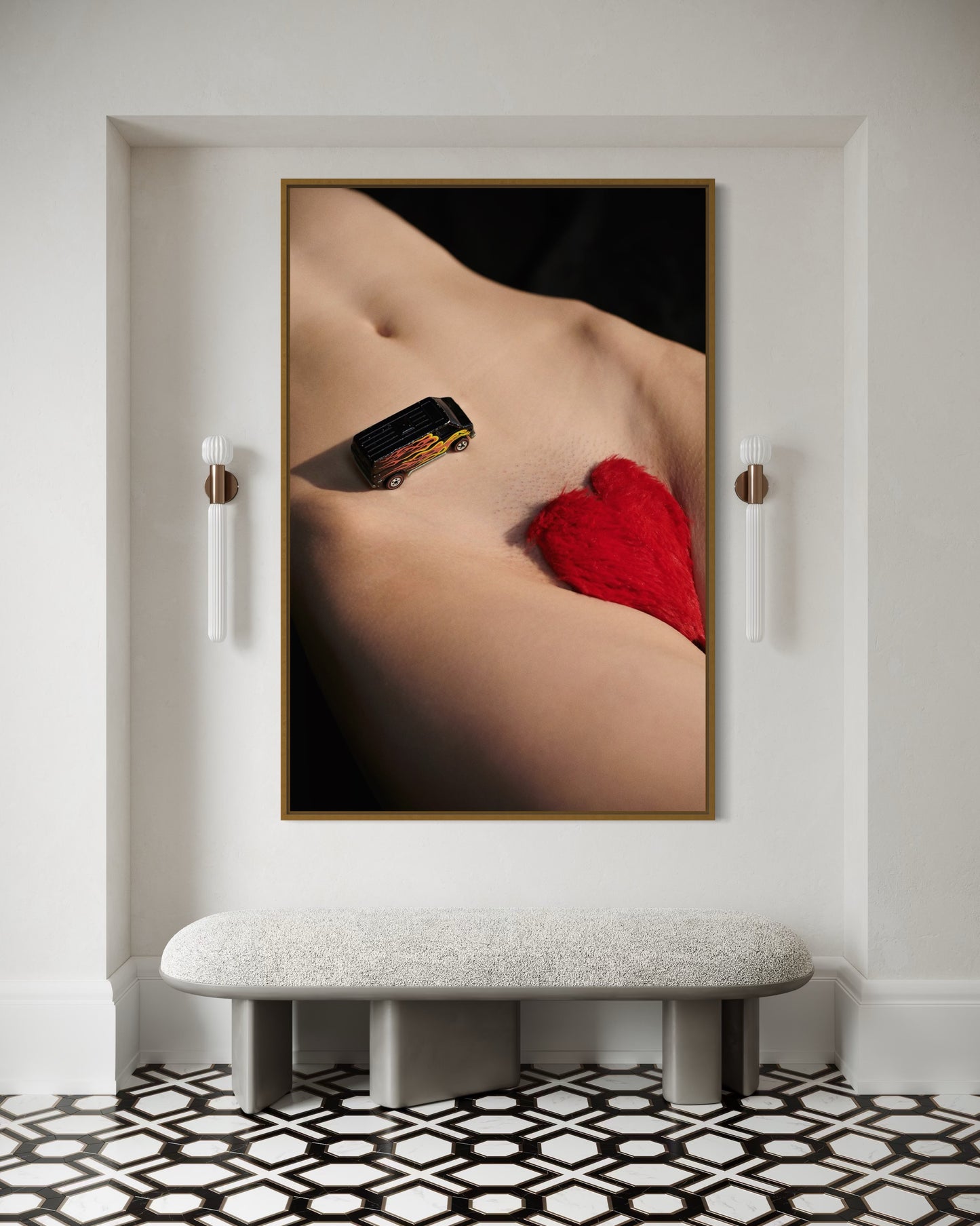 Framed artwork of a nude figure with red heart pubic hair and a miniature car driving down her stomach.
