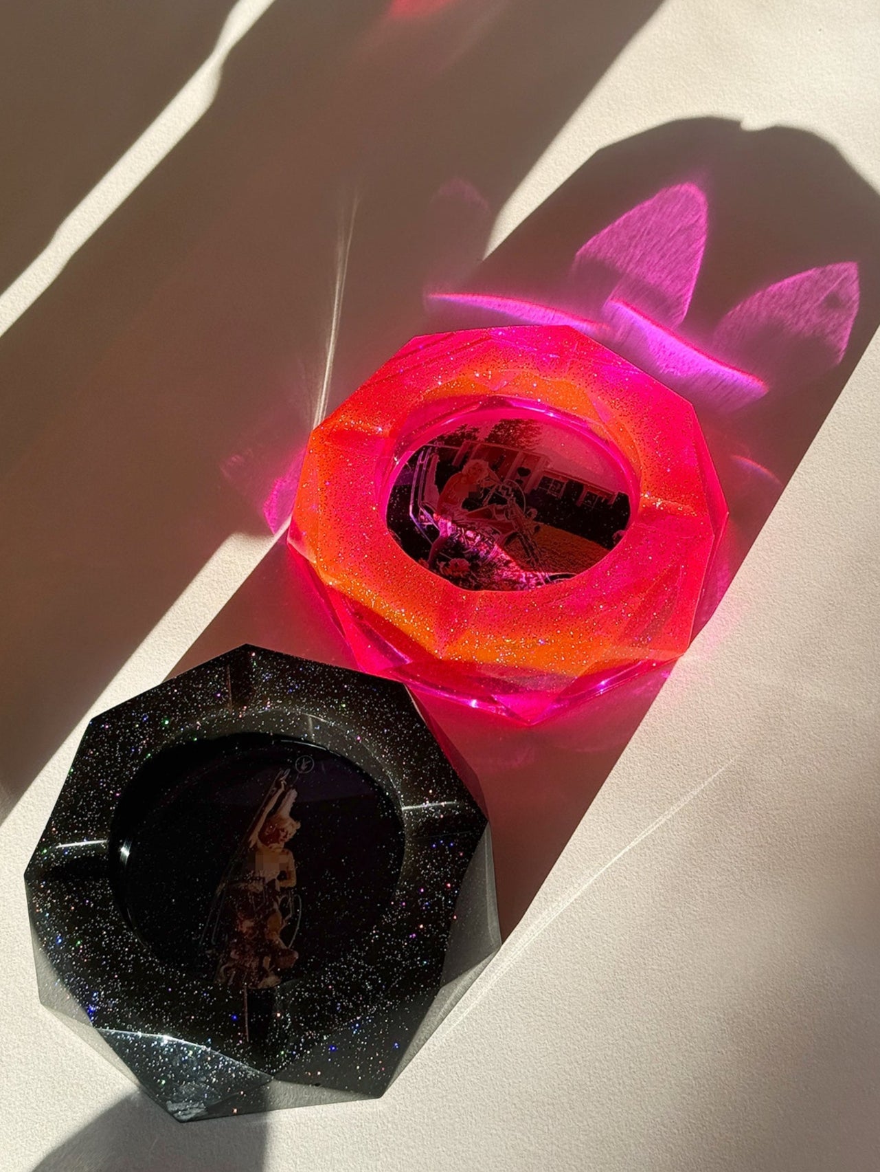 Two colorful plastic objects on a light surface with shadows.