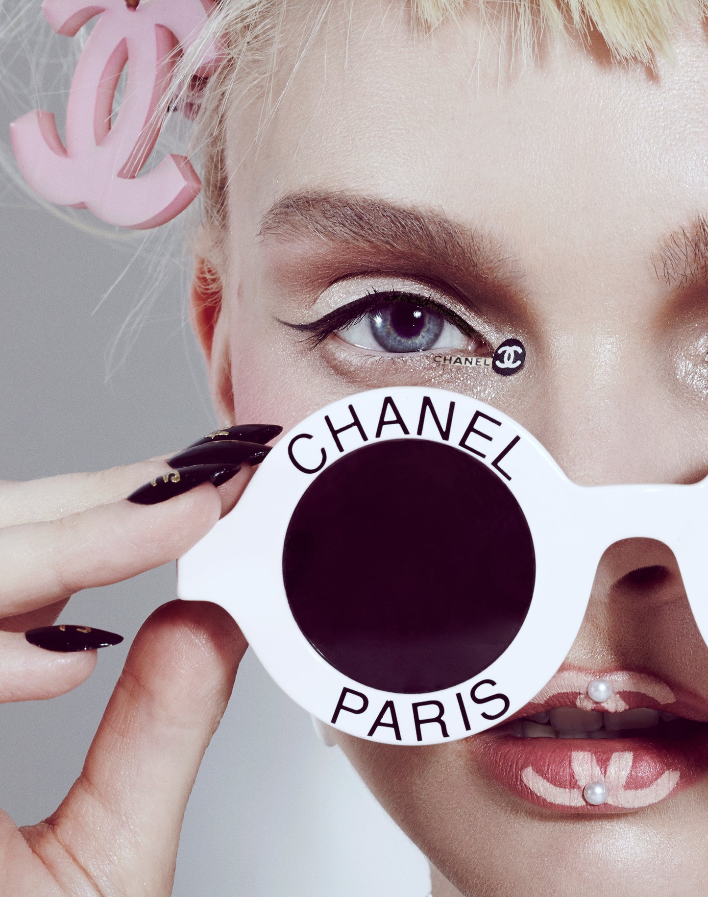 Close-up of label whore woman girl wearing Chanel sunglasses with chanel logo lips and pearl makeup