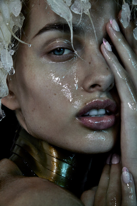 Model girl with wet skin and frozen icicle hair and clear iridescent nails manicure avant garde-makeup campaign.
