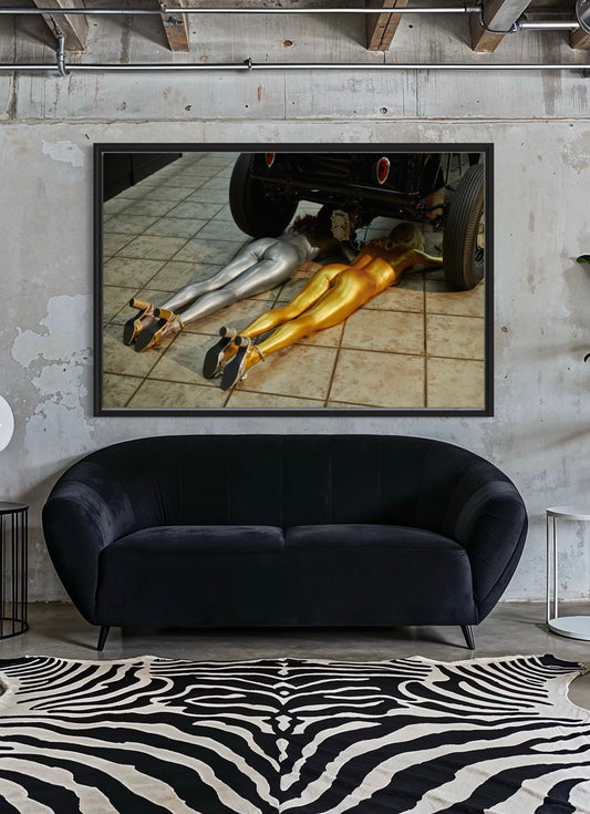 Black sofa in a room with a large framed artwork of two people underneath a car.