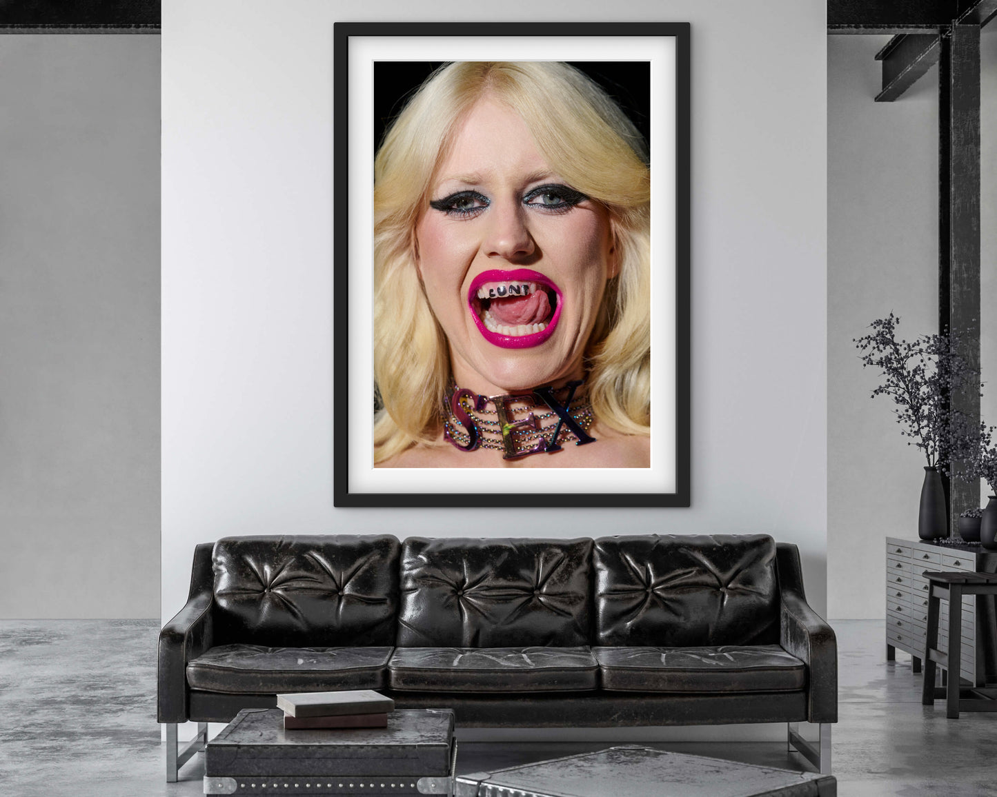 Punk woman Amy Taylor (Amyl and the Sniffers) wearing neon pink lipstick and licking her teeth that have 'CUNT' written on them.