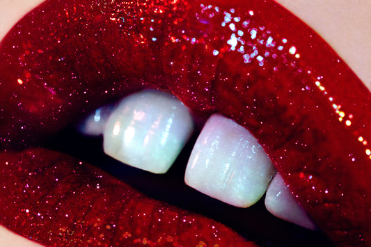 Close-up of lips with red glitter and gap teeth, creating a dramatic and galactic aesthetic.