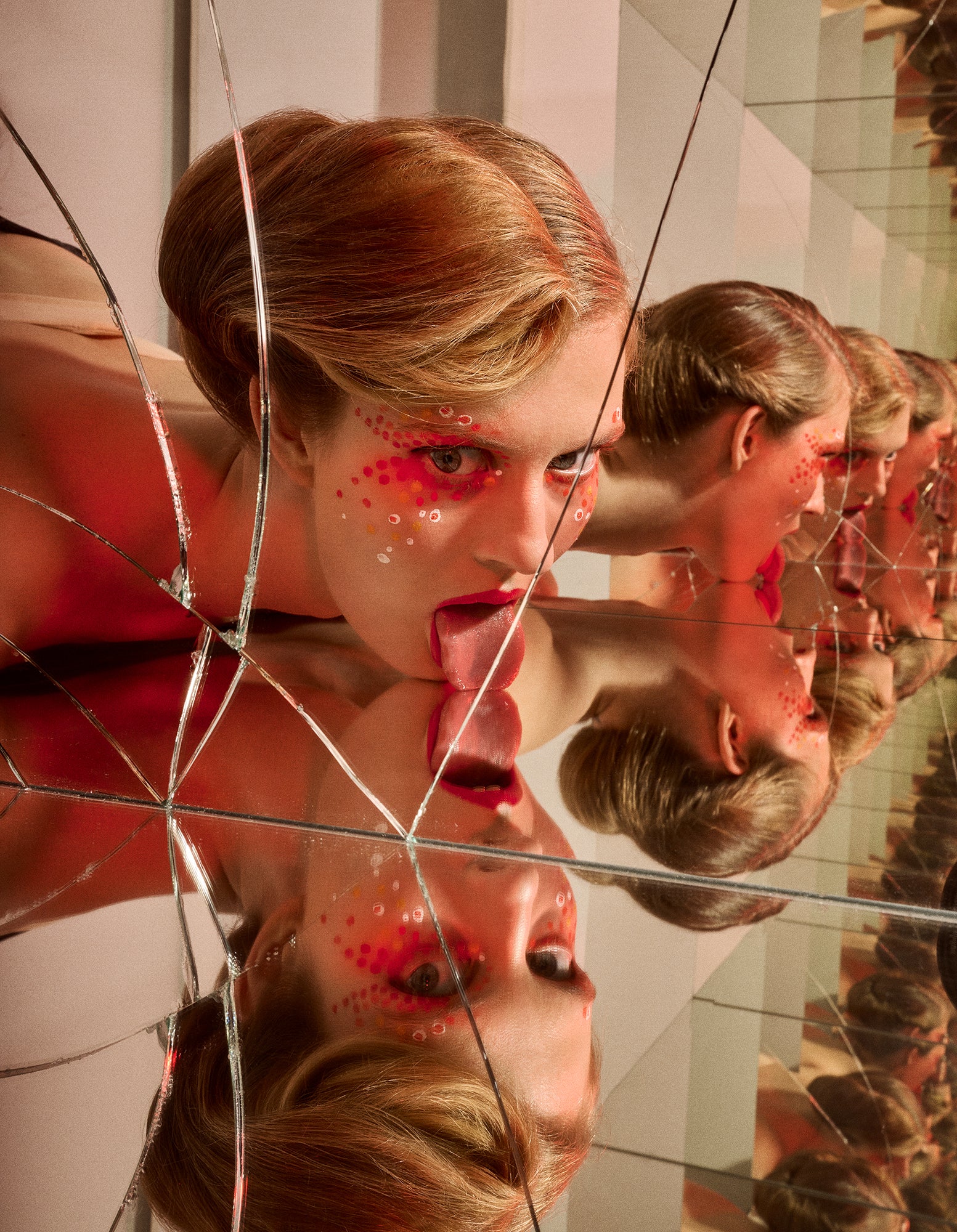 A creative artwork depicting a person with a bun hairdo looking into a cracked mirror with multiple reflections, with red avant garde makeup on the face.