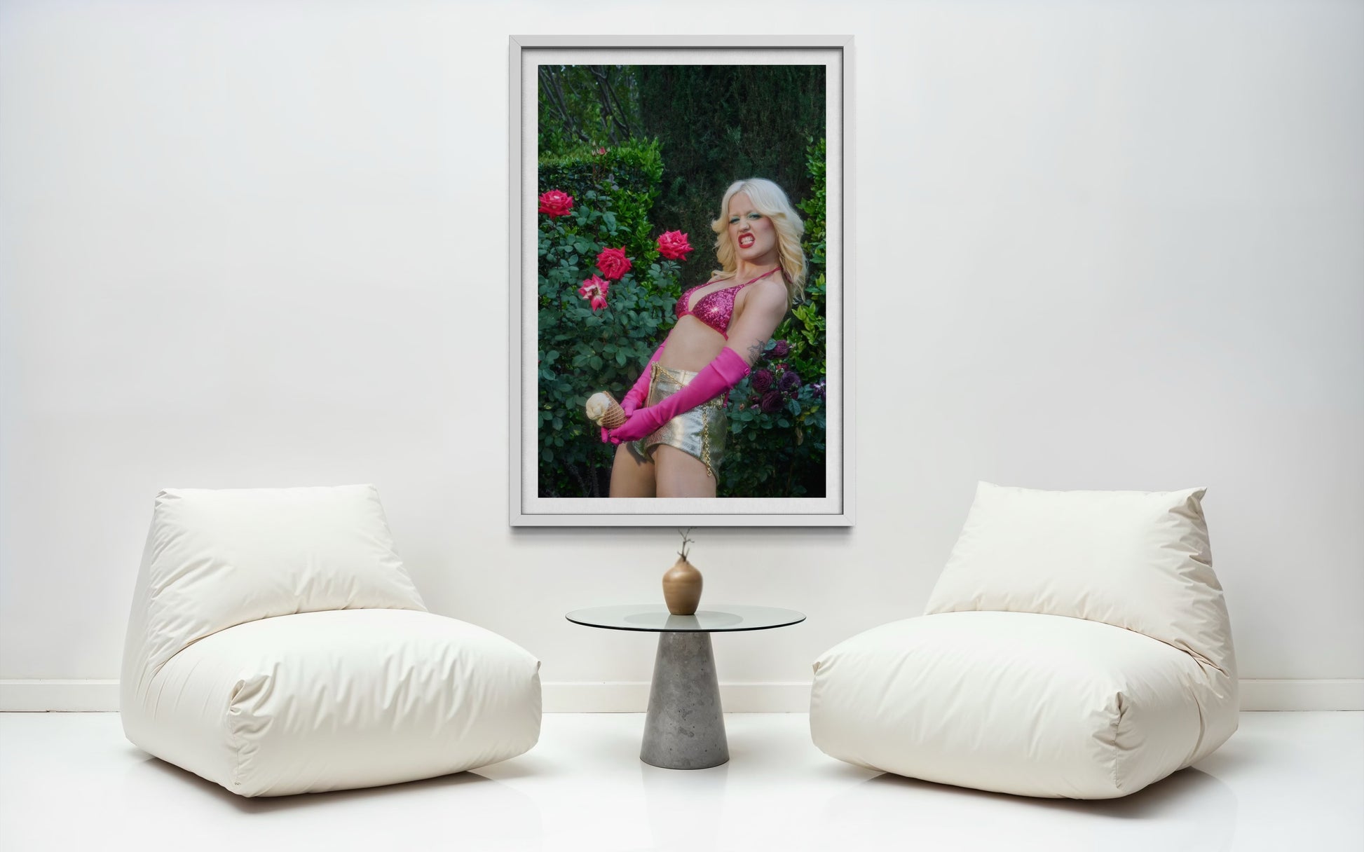 Artwork of Amyl and the Sniffers' Amy Taylor in a rose garden. She wears a pink bikini and pink gloves as she grits her teeth and holds an ice cream cone suggestively.