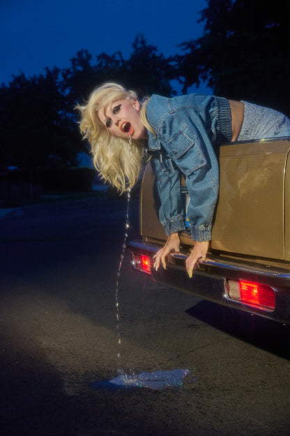 Amy Taylor, front woman to the band Amyl and the Sniffers, throwing up out of the back of an El Camino, Hollywood style.