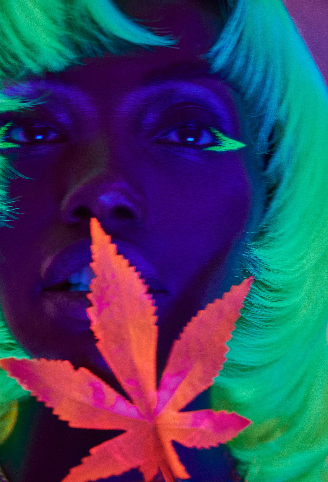 UV blacklight colorful fine art of black woman at a club with glow-in-the-dark neon green raver hair and neon orange pot leaf cannabis near her mouth