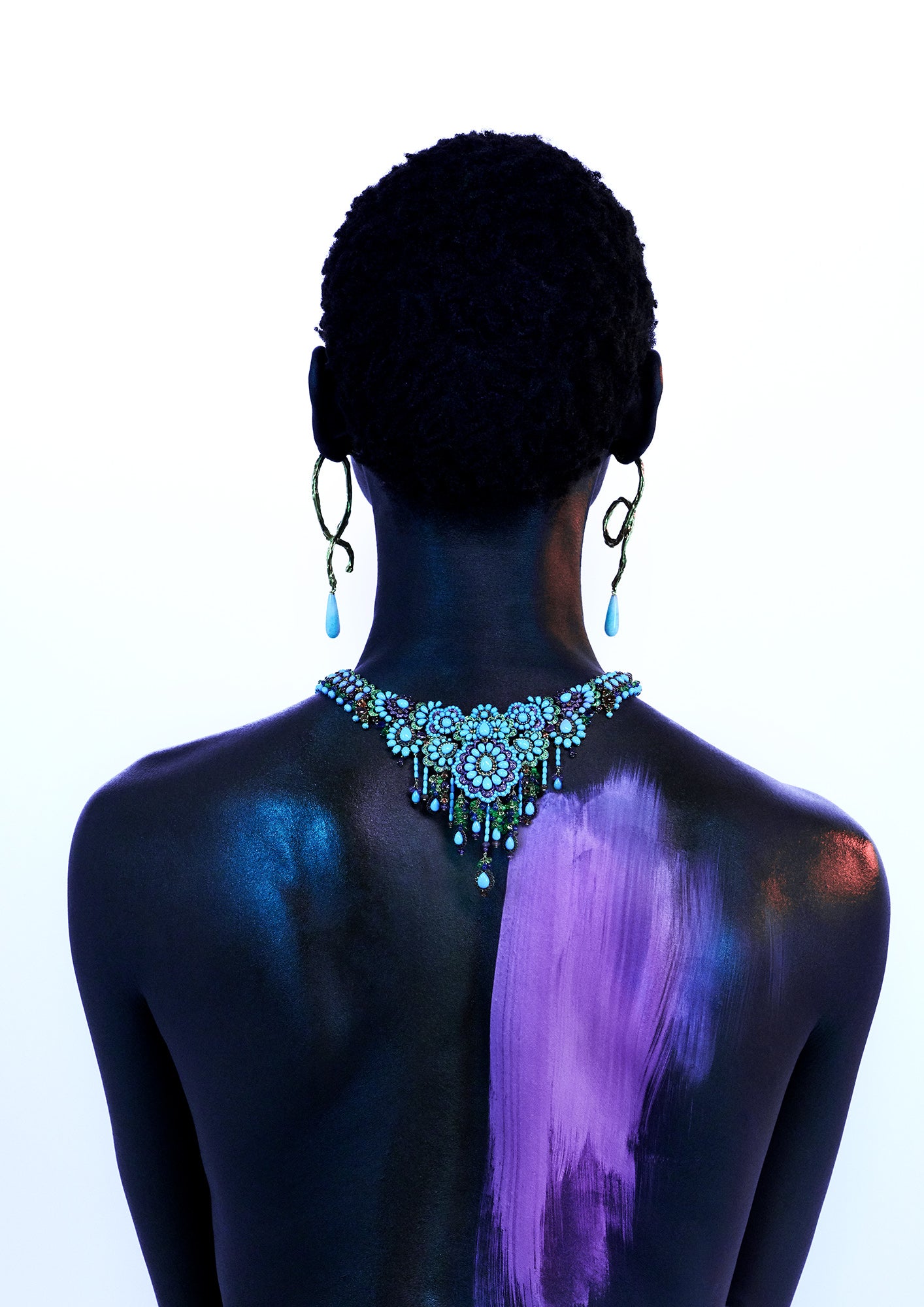 Beauty Editorial of African Model's back wearing earrings with pink paint streak