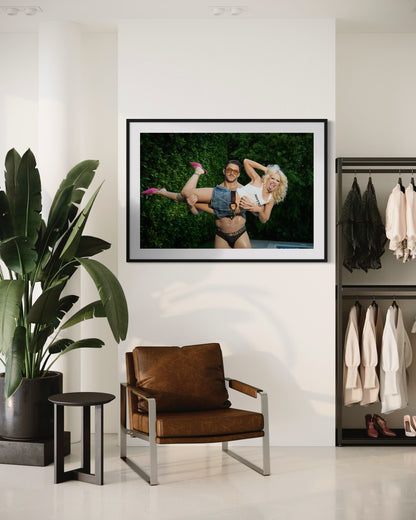 Framed photograph of a buff guy lifting up a blonde woman, Amy Taylor of Amyl and the Sniffers as she sticks her tongue out and smiles.