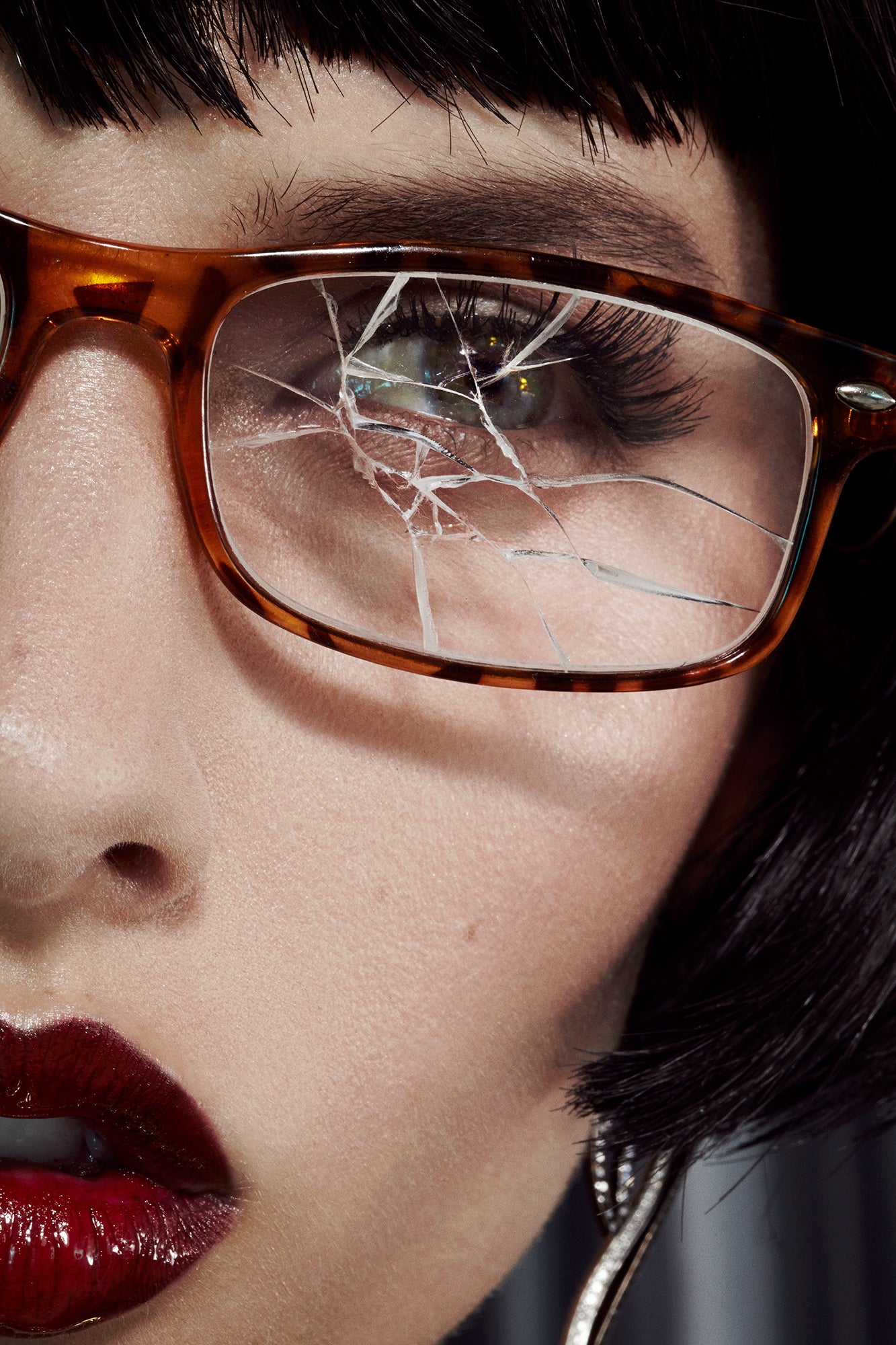 close-up of girl female model with black bob and broken prescription tortoise eye glasses beauty editorial