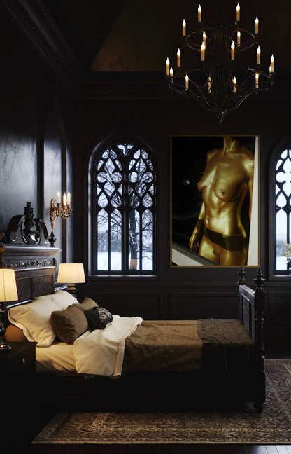 Darkly decorated room with gothic window, chandelier, and framed artwork of a woman's nude torso painted in gold.