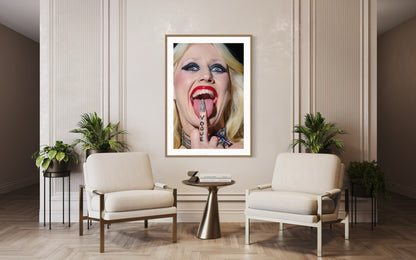 Modern living room with a framed artwork of a woman's face on the wall, two chairs, and a small table.