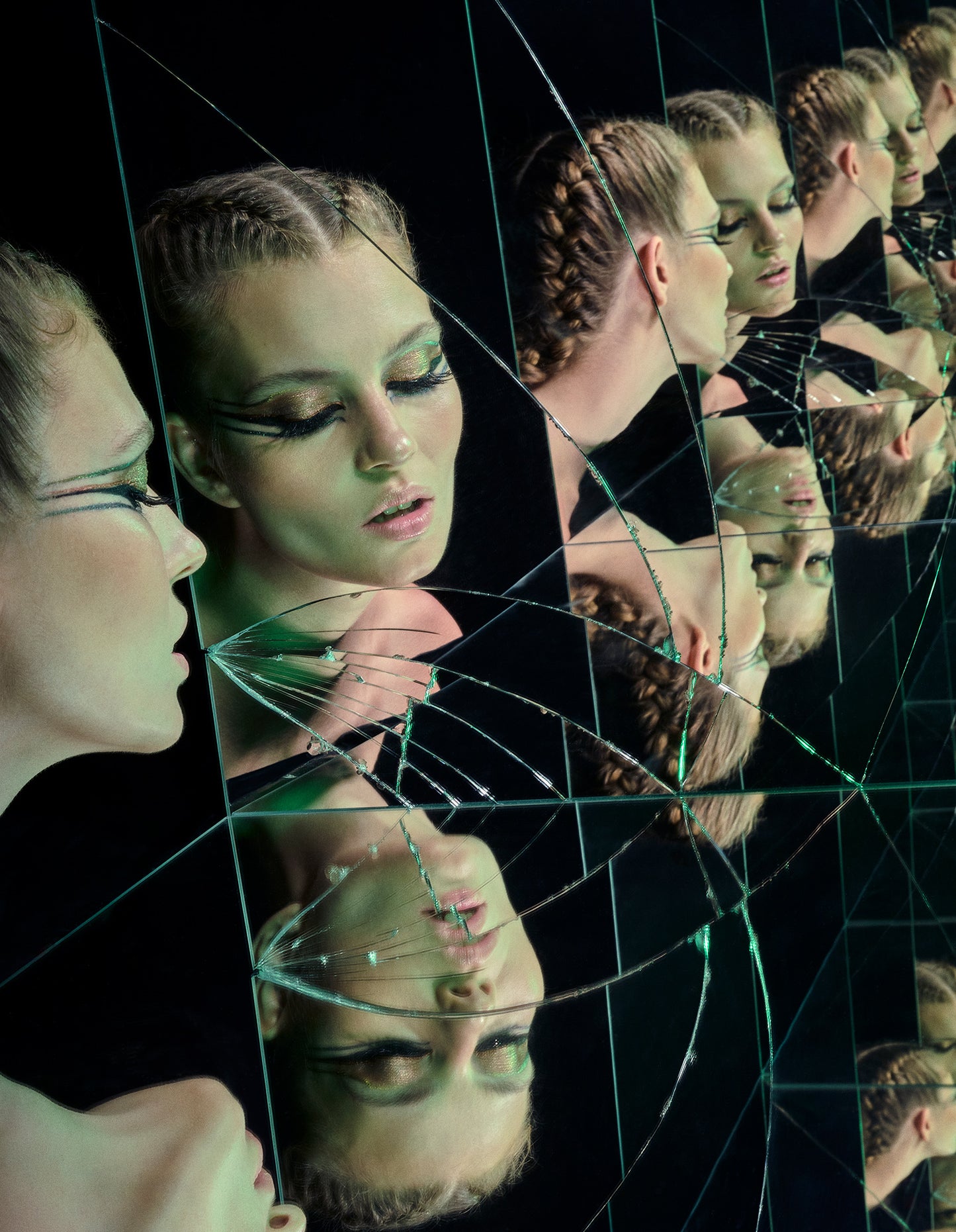 woman with avant-garde eyeliner and fishtail braids looking into broken shattered mirror vogue beauty editorial