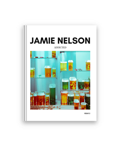 Book cover with 'Jamie Nelson' and 'Addicted' text, featuring a fine art image of of pills in a medicine cabinet.