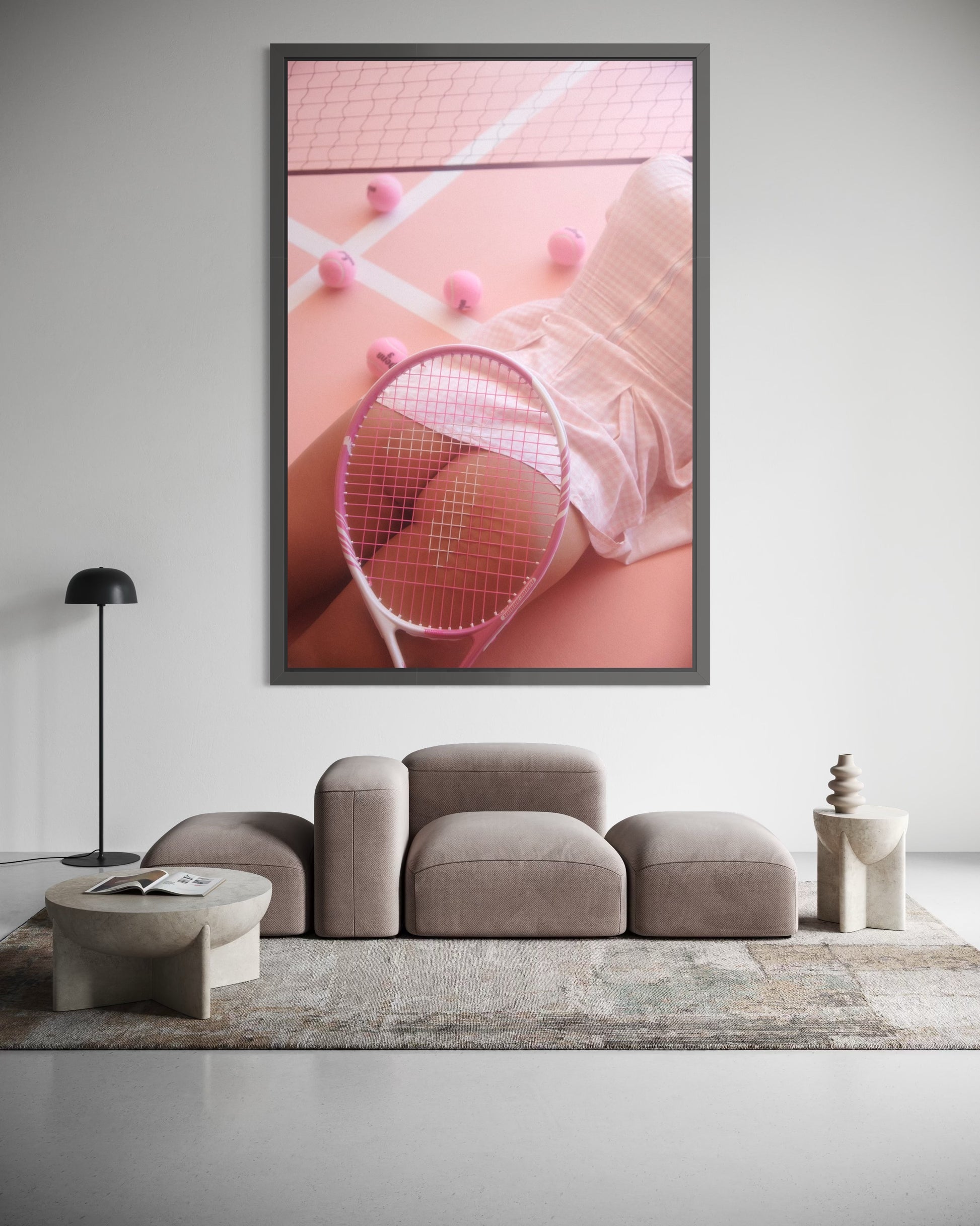 Framed artwork of a woman lying on a pink tennis court surrounded by pink tennis balls. A tennis racquet is placed over her nude buttocks.