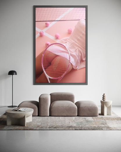 Framed artwork of a woman lying on a pink tennis court surrounded by pink tennis balls. A tennis racquet is placed over her nude buttocks.