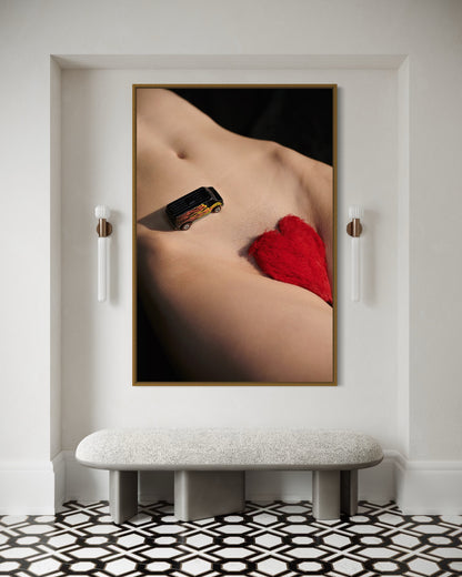Framed artwork of a nude figure with red heart pubic hair and a miniature car driving down her stomach.