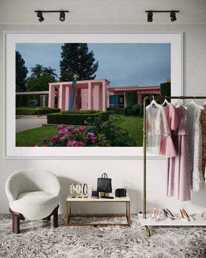 Framed photograph of a pink building with greenery in a stylish interior setting.
