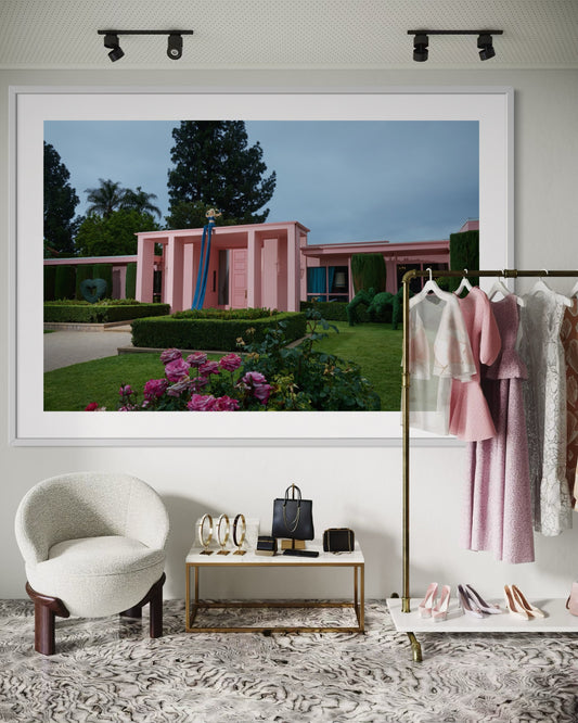 Framed photograph of a pink building with greenery in a stylish interior setting.