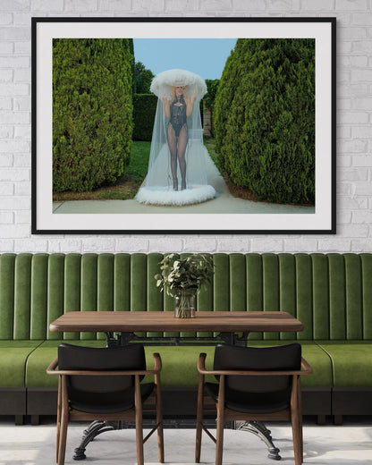 Framed artwork of a punk woman Amy Taylor of Amyl and the Sniffers as she flips the camera off while wearing a white veiled hat in a garden setting.