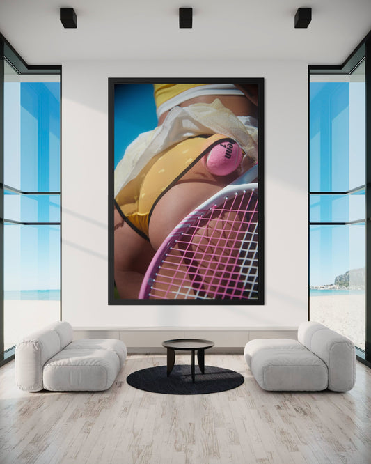 Modern luxurious ocean view interior with a large framed picture of a tennis player's butt on the wall.