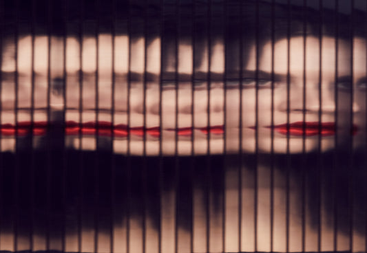 Woman looking into fragmented flatter infinity mirror with multiple reflections