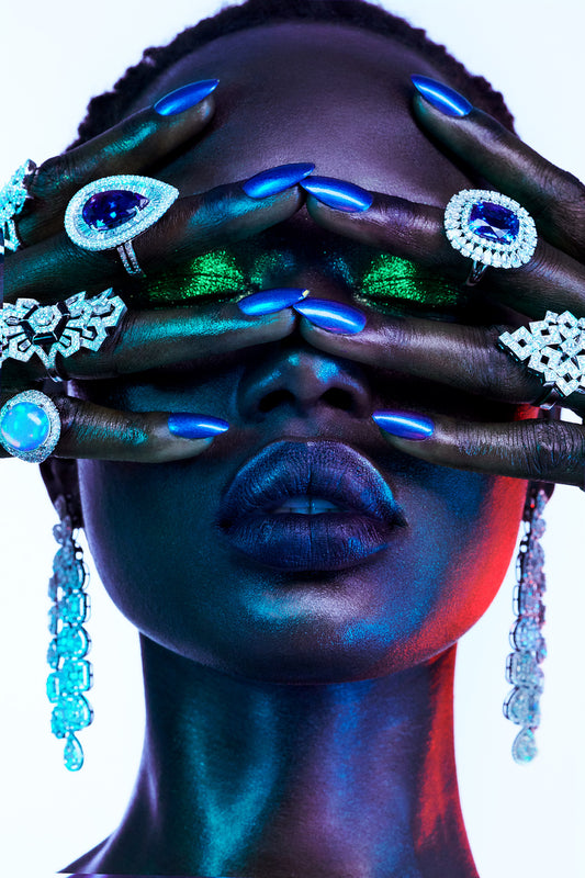 Vogue Beauty Editorial portrait of black woman, Ajak Deng, covering her metallic green eyes with her hands covered in fine jewelry