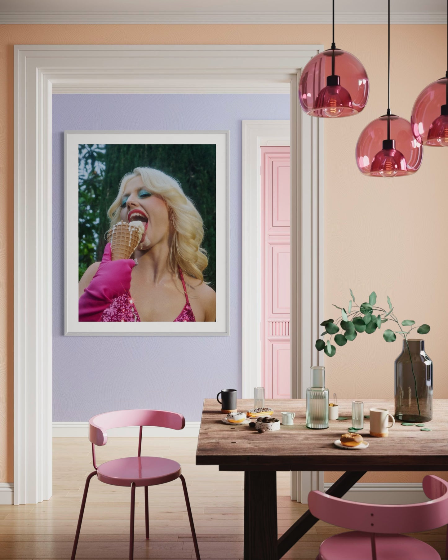Dining room with a framed picture of a woman eating ice cream, pink chairs, and pink pendant lights.