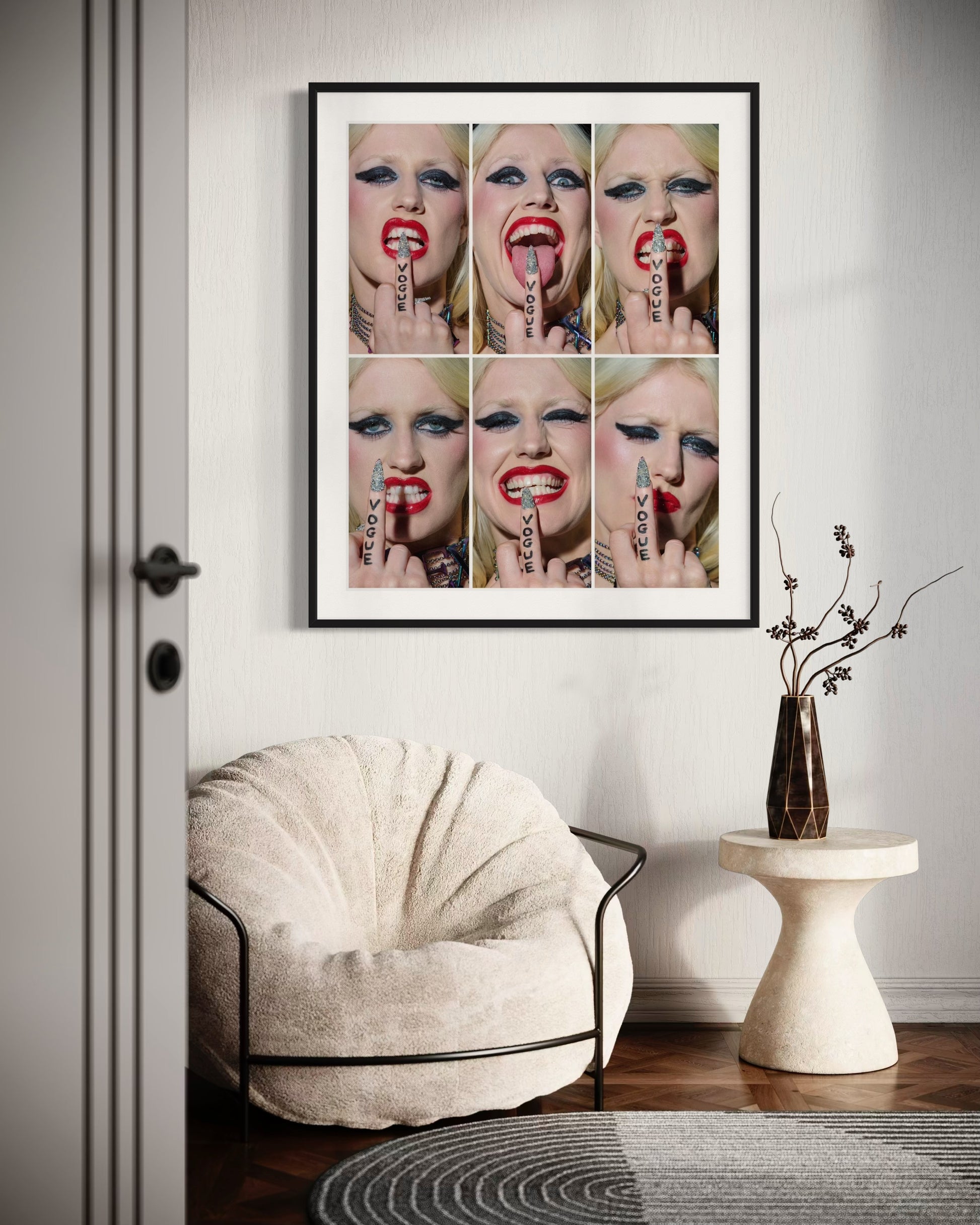 Framed artwork of a woman's face with tattoos on a wall above a chair and table.