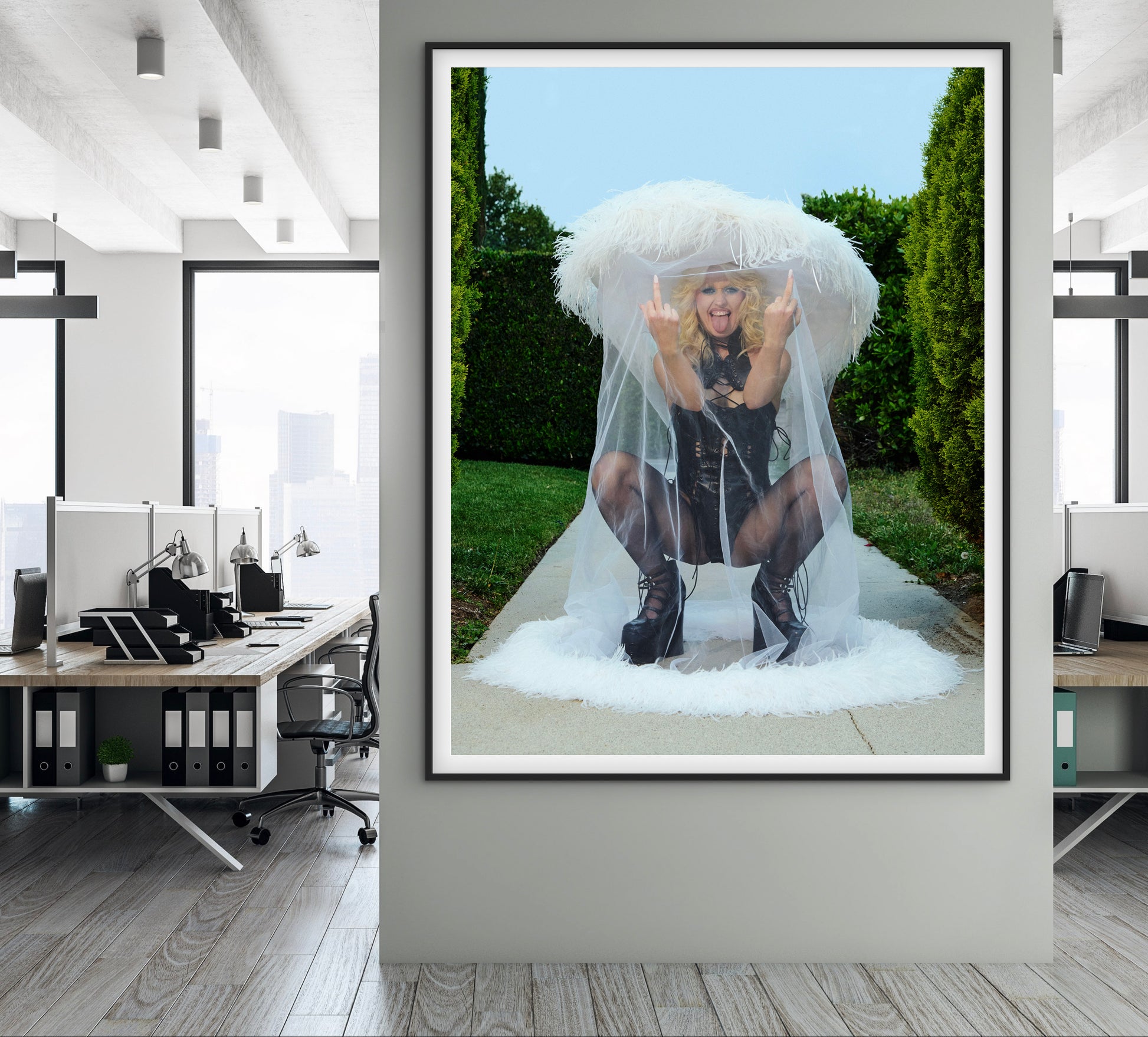 Woman flipping off camera wearing large hat and veil in a garden setting.