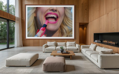 Framed artwork of a close-up photo of a blonde woman (Amy Taylor, punk singer for Amyl and the Sniffers) applying a pink lipstick bullet that is shaped like a penis.