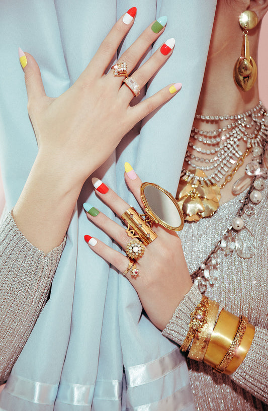 female model girl peeks from behind blue curtain with colorful pastel vintage manicure fingernails wearing vintage jewelry