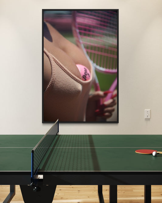 Framed artistic picture of a woman wearing vintage attire holding a pink tennis racket on a wall above a ping pong table.
