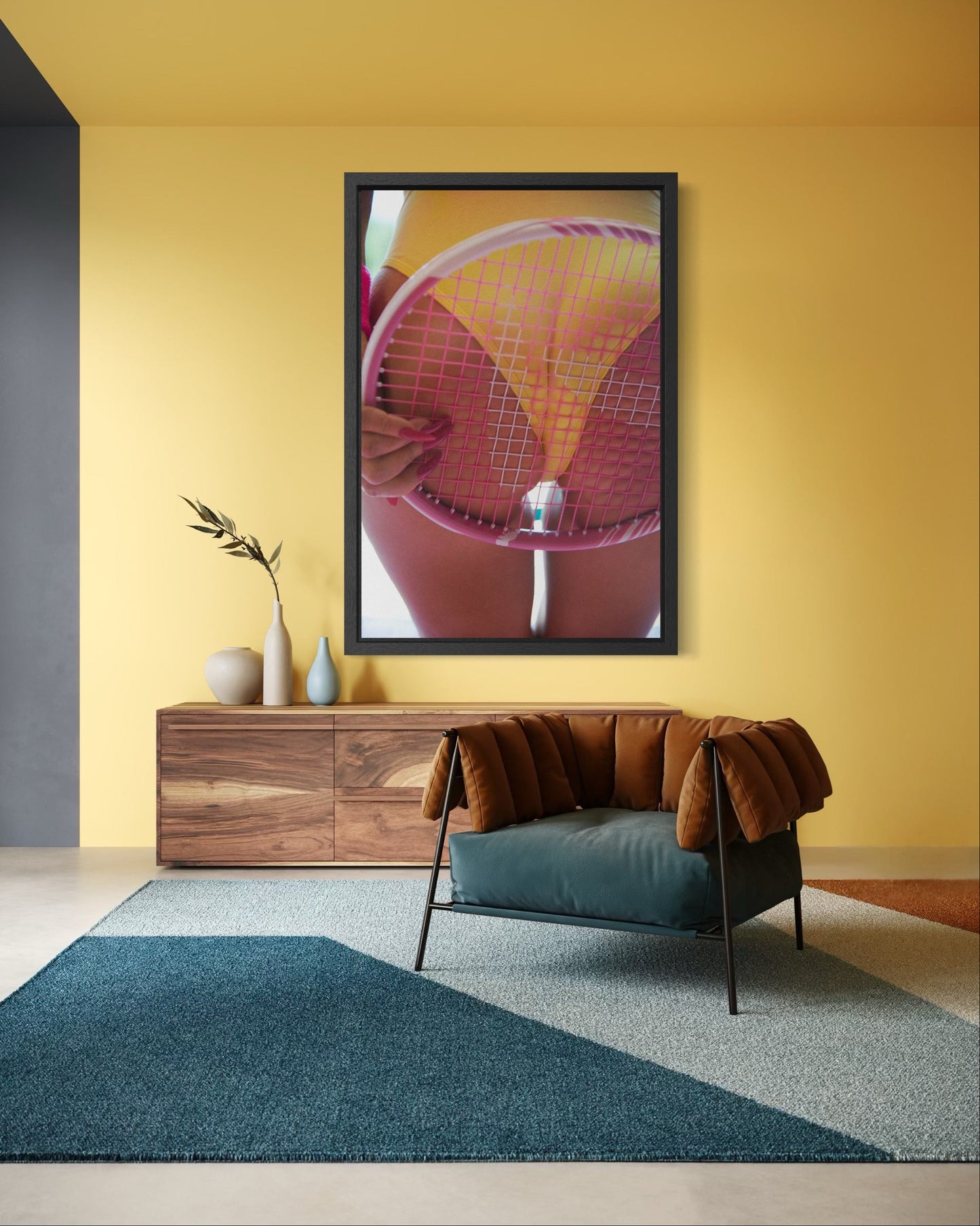 Modern yellow living room with a large framed artwork of a woman's butt in a yellow leotard with a tennis racquet pushed against it.